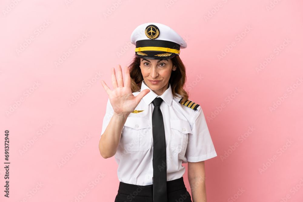 Airplane middle aged pilot woman isolated on pink background counting five with fingers Airplane middle aged pilot woman isolated on pink background counting five with fingers