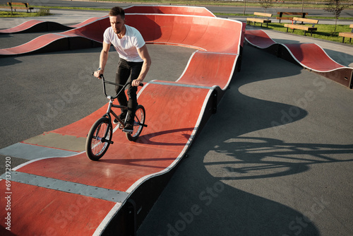 Man riding BMX bike on sports track in park photo