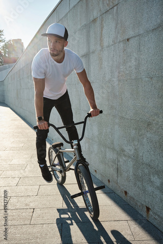 Man riding BMX bike near concrete wall photo