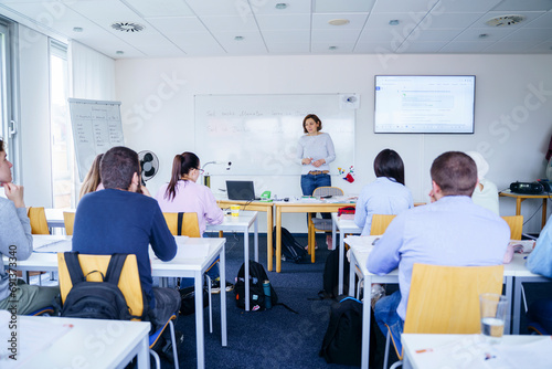 Woman teaching to multi-ethnic students in classroom photo