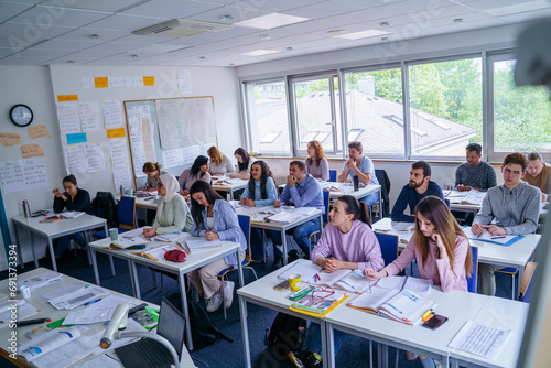 Multi-ethnic students at desk learning in educational training class photo