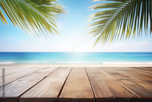 Empty wooden table and palm leaves with party on beach blurred background and beautiful sea 
