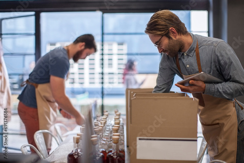 Two colleagues shipping liquor in a distillery photo