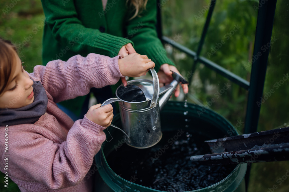 Ταπετσαρία Girl and mother scooping rainwater from barell under downspout