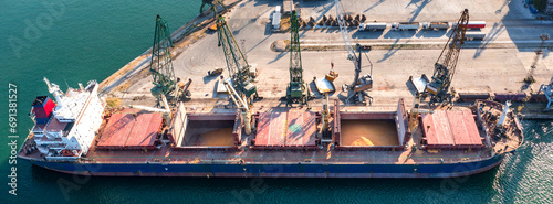 Panoramic view from a drone of a large ship loading grain for export. Water transport
