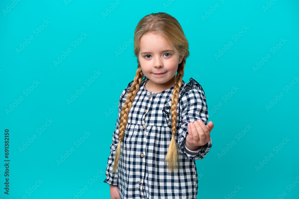 Little caucasian girl isolated on blue background inviting to come with hand. Happy that you came Little caucasian girl isolated on blue background inviting to come with hand. Happy that you came