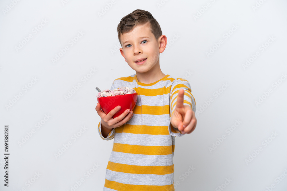 Little caucasian boy holding a cereal bowl isolated on white background showing and lifting a finger Little caucasian boy holding a cereal bowl isolated on white background showing and lifting a finger