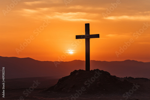 Christian cross on a hill against the backdrop of a sunset sky, desert and mountains as a symbol of redemption.​