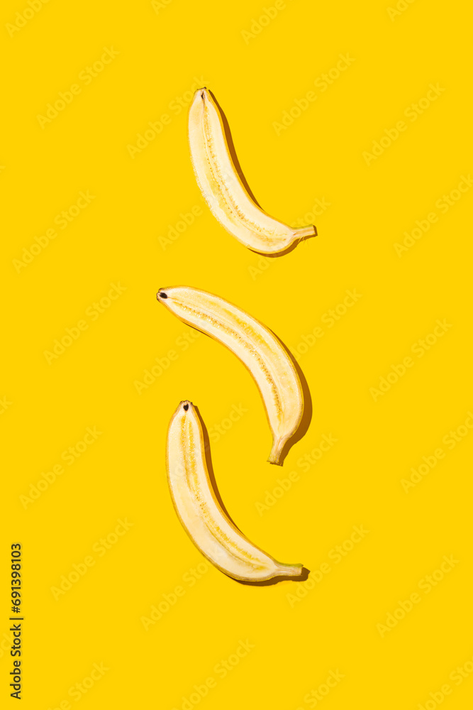 Half of bananas on bright yellow background. Half of bananas on bright yellow background.