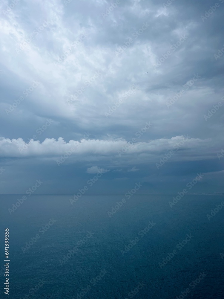 Dark rainy clouds at the sea, cloudy seascape, deep blue sea horizon
