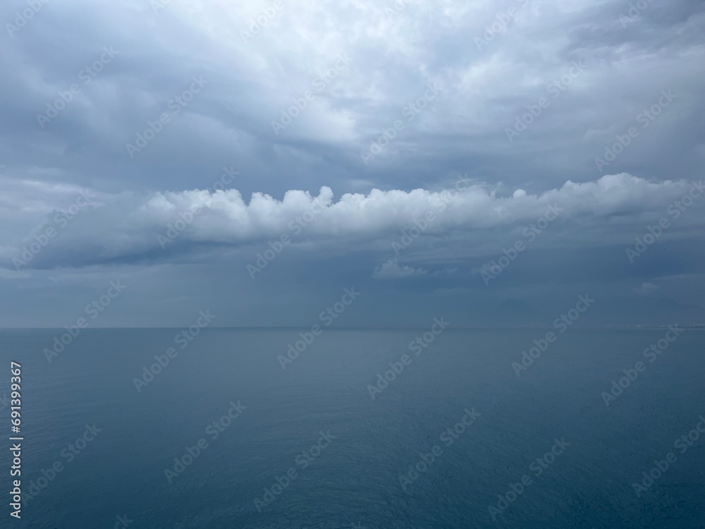 Dark rainy clouds at the sea, cloudy seascape, deep blue sea horizon Dark rainy clouds at the sea, cloudy seascape, deep blue sea horizon