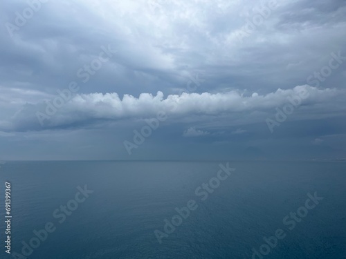 Dark rainy clouds at the sea, cloudy seascape, deep blue sea horizon