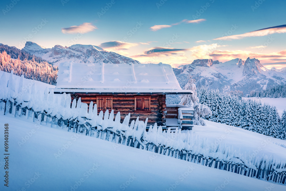 Wooden chalet on the hill of Alpe di Siusi village. Snowy winter sunrise on Dolomite Alps. Picturesque landscape of ski resort, Ityaly, Europe. Beauty of countryside concept background.. - obrazy, fototapety, plakaty 