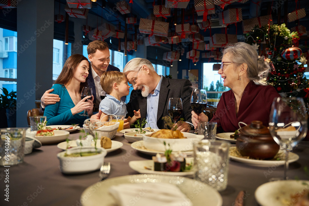 Cheerful family celebrating New Years Eve together in restaurant Christmas time