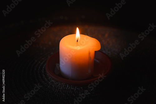 A burning candle.Bright light on dark background.RIP darkness template. lighting a candle in the darkness.