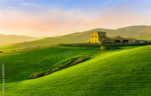 scenery rural view of a contryside farm in green fields and hills with amazing cloudy sky on background photo