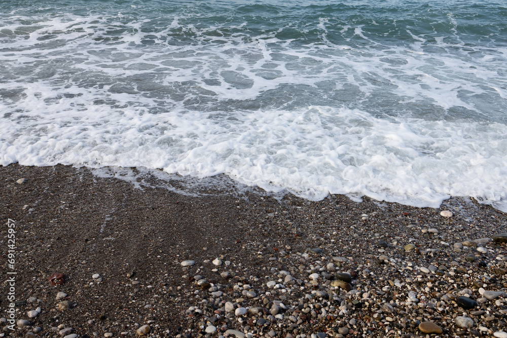 Low sea surf on a pebble beach. Montenegro Low sea surf on a pebble beach. Montenegro