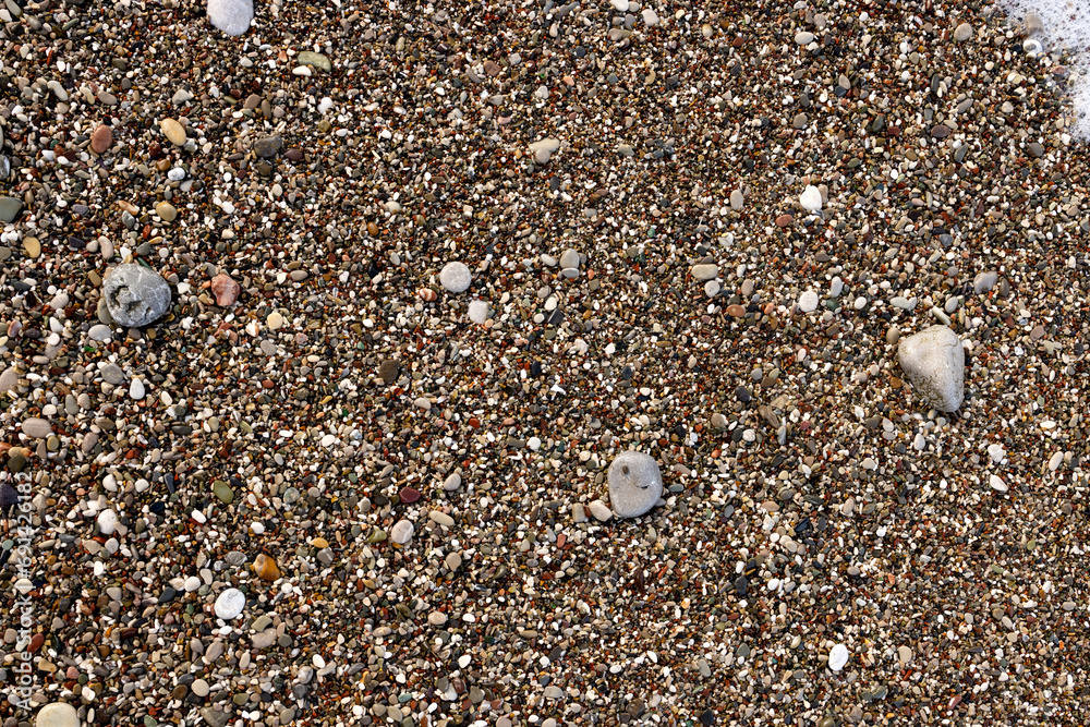 Rounded small pebbles with rare large quartz pebbles on the beach in Montenegro Rounded small pebbles with rare large quartz pebbles on the beach in Montenegro