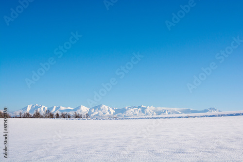 冬の晴れた日の雪原と山並み 十勝岳連峰 