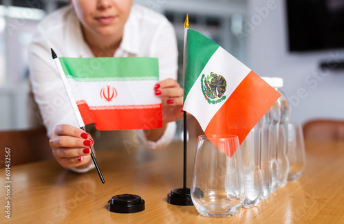 Secretary shows the flags of Mexico and Iran on the table. Preparing for a meeting, negotiations. photo