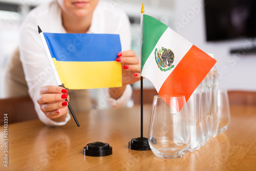Secretary shows the flags of Mexico and Ukraine on the table. Preparing for a meeting, negotiations. photo