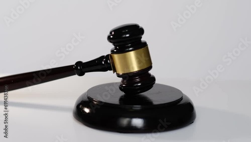 A gavel rests on its sound block against a white background, symbolizing authority and the rule of law. photo