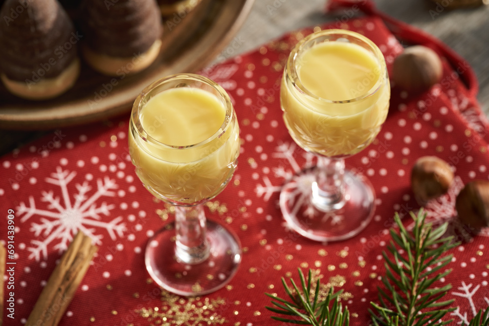 Creamy eggnog in two glasses with Christmas cookies and decoration Creamy eggnog in two glasses with Christmas cookies and decoration