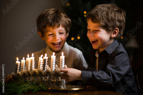 Small smiling jewish boys lighting menorah candles to celebrate Hanukkah holiday