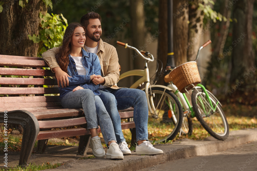 Fototapeta premium Beautiful couple spending time together in park, space for text
