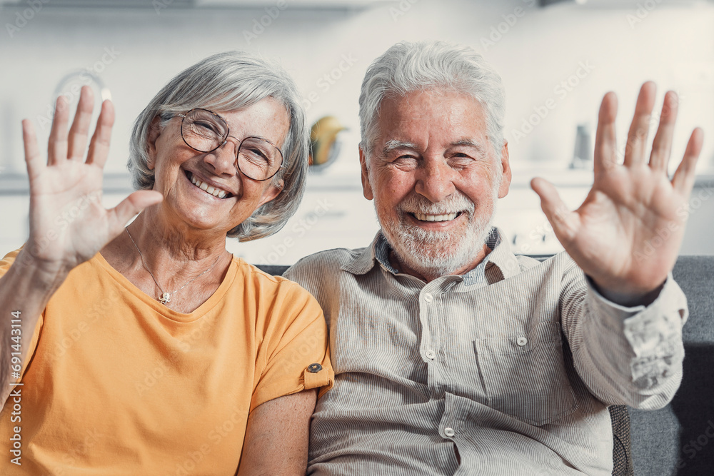 Sixty years couple, elderly parents communicates with grown up children using modern technologies makes video call, wave hands gesture of hello or goodbye sign, older generation and internet concept. Sixty years couple, elderly parents communicates with grown up children using modern technologies makes video call, wave hands gesture of hello or goodbye sign, older generation and internet concept.