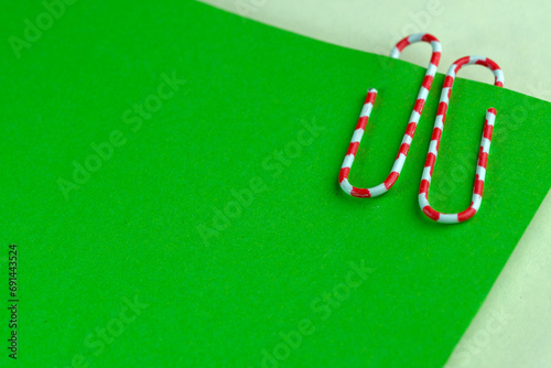 Red paperclip on green blank sheets