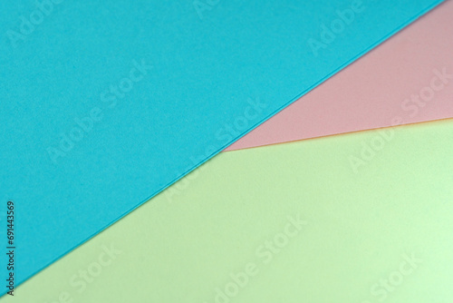 Sheets of colored paper lie at an angle