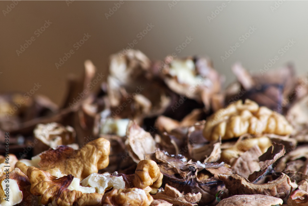 Walnut kernels mixed with broken shells spread over the table close-up. Walnut kernels mixed with broken shells spread over the table close-up.