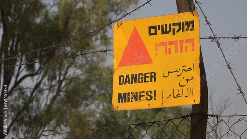 Warning sign against old landmines (from the 1950s and 1960s), written in Hebrew, English, and Arabic, on the Golan Heights in Israel
 photo