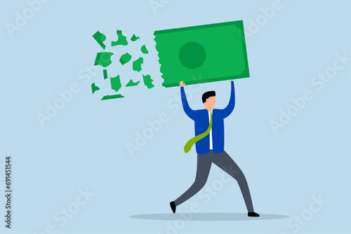 Lose money investment in financial crisis, Businessman holding large dollar banknote money as it deteriorates, crumbles, and loses value.