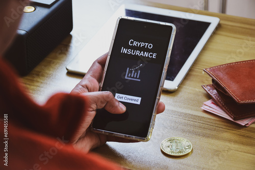Man deciding on getting covered by crypto insurance policy to protect his crypto assets using smartphone mobile application. Selective focus. photo