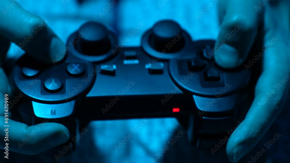 Hand playing on video game controller, close-up