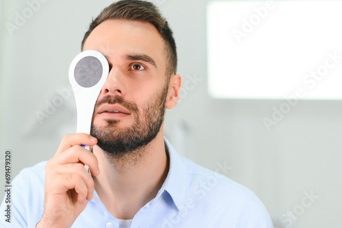 Portrait, vision and spoon with a man patient at the optometrist for an eye exam testing his depth perception