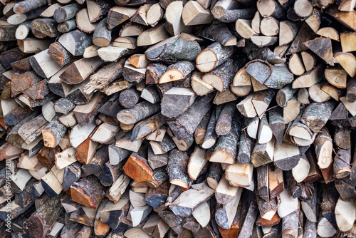 stack of firewood for fireplace at winter time, abstract background close-up. Expensive electricity concept