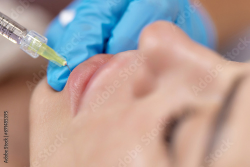 Wallpaper Mural cosmetologist makes injections to enlarge the lips of beautiful woman. procedure lip augmentation Torontodigital.ca