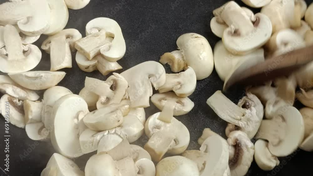 champignons de Paris cuisant dans une poêle champignons de Paris cuisant dans une poêle