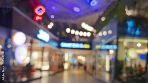 The blurry background of a lively shopping center corridor.