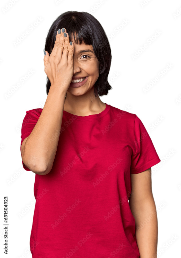 Young Hispanic woman with short black hair in studio having fun covering half of face with palm. Young Hispanic woman with short black hair in studio having fun covering half of face with palm.