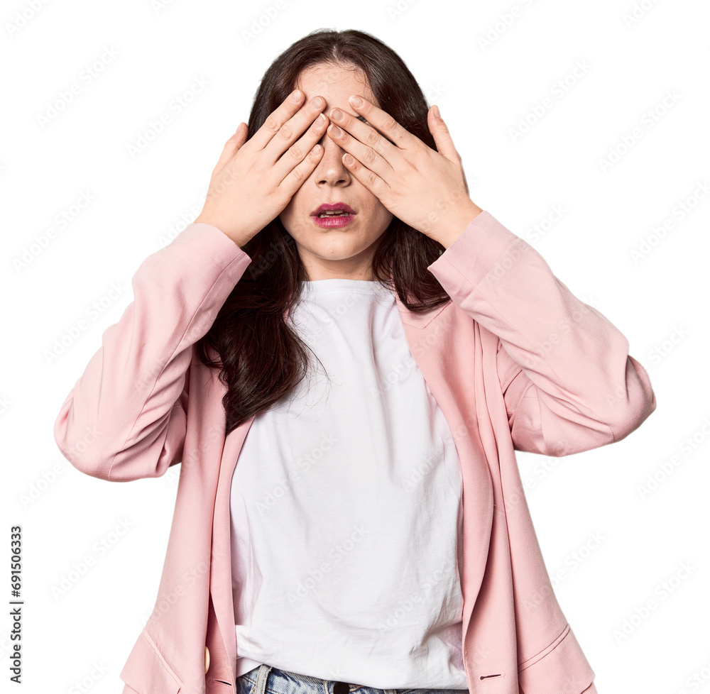 Young Caucasian woman in a studio setting afraid covering eyes with hands. Young Caucasian woman in a studio setting afraid covering eyes with hands.