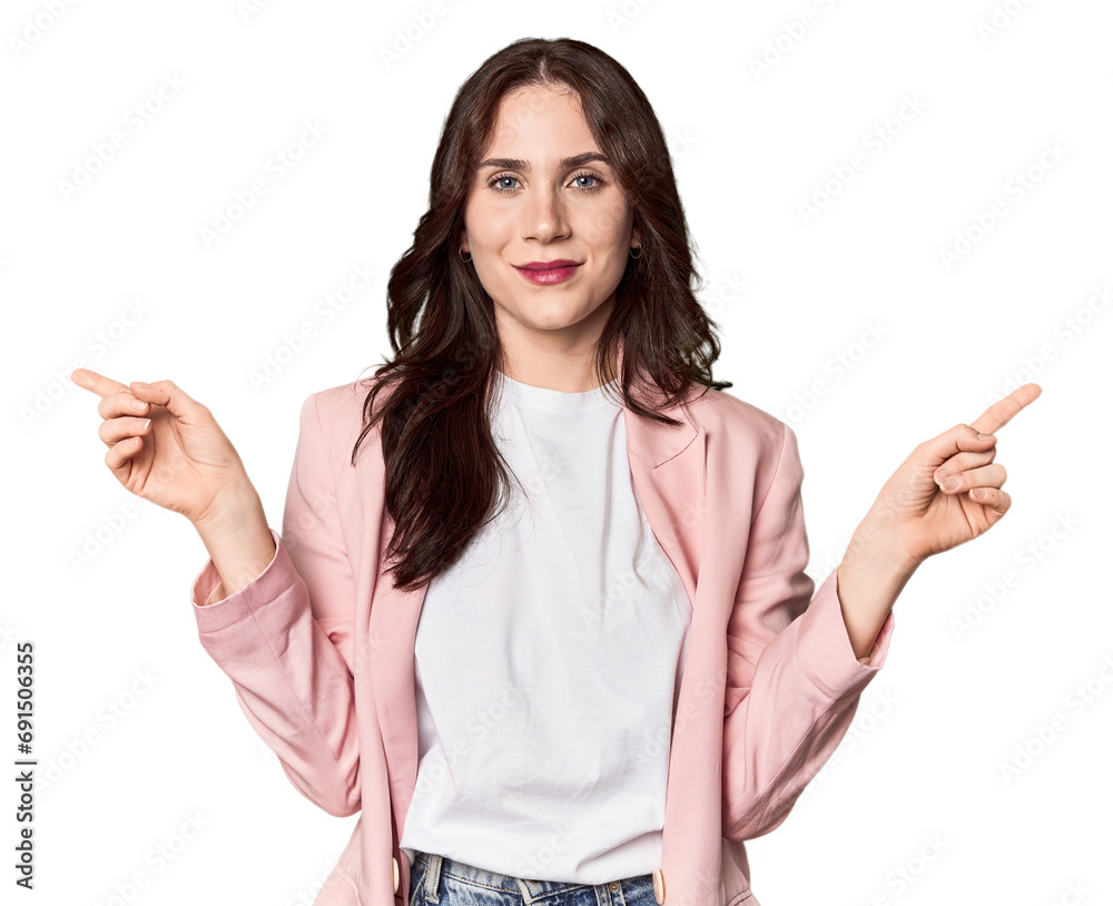 Young Caucasian woman in a studio setting pointing to different copy spaces, choosing one of them, showing with finger. Young Caucasian woman in a studio setting pointing to different copy spaces, choosing one of them, showing with finger.