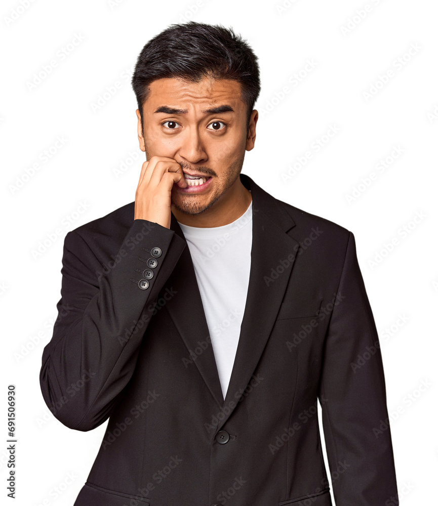 Young Chinese man in business suit in studio biting fingernails, nervous and very anxious. Young Chinese man in business suit in studio biting fingernails, nervous and very anxious.