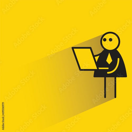 businessman working on laptop with shadow on yellow background