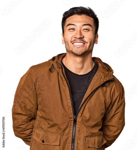 Young Chinese man in studio background happy, smiling and cheerful.