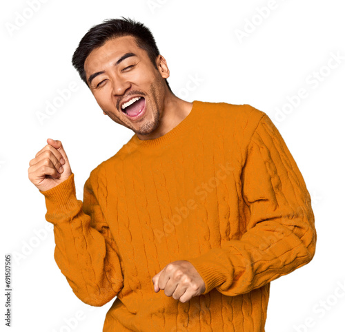 Young Chinese man in studio background dancing and having fun. photo