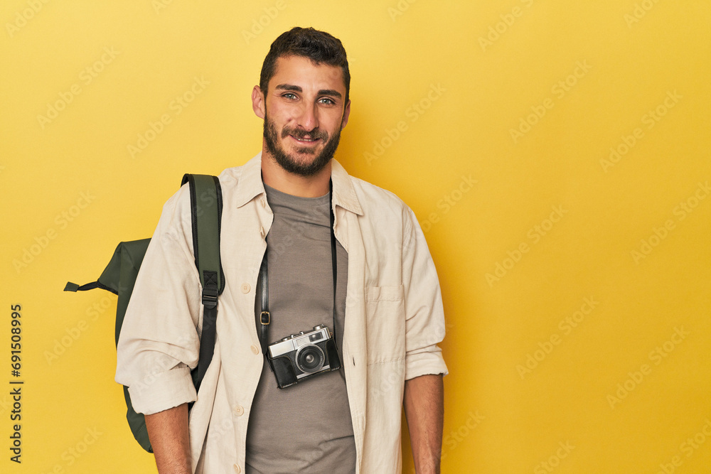 Fototapeta premium Young Hispanic travel photographer poses happy, smiling and cheerful.
